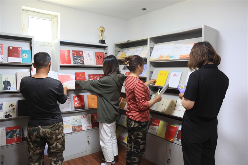 图为一七〇团六连农家书屋内，职工群众正在借阅书籍（马晶晶摄） .jpg